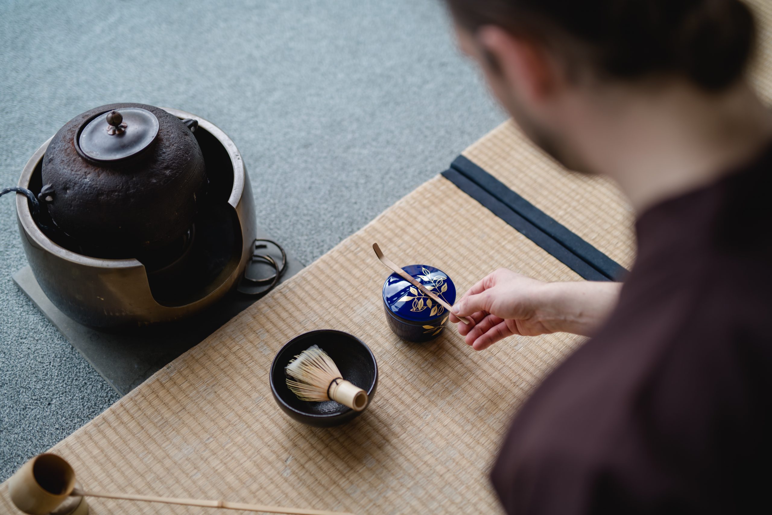 Displays a starting setting for japanese teaceremony, teabowl and utensils prepared, Bernhard Engelmann starting to pick up the teaspoon in order to clean it