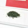 Japanischer Sencha von Marukyu Koyamaen in roter Papierverpackung, grüner Tee im Vordergund